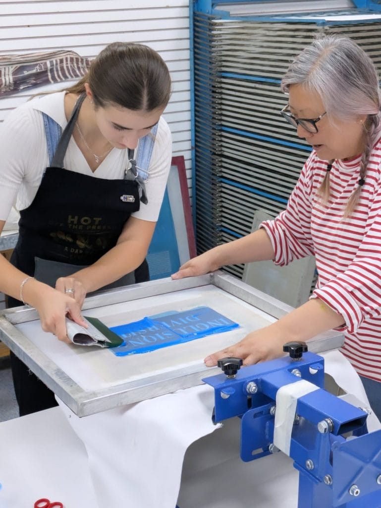 Mary Jennings working with Wendy from What If We Create CIC to screen print her Miss World Cape