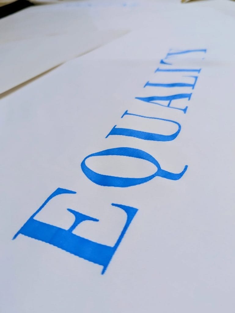 Equality screen printed on to Lenzing fibre cape.